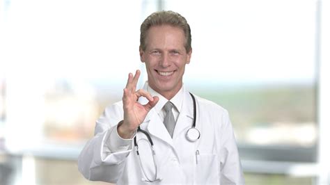 middle aged doctor gesturing ok happy male doctor showing ok sign blurred background medicine
