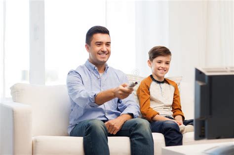 Smiling Father And Son Watching Tv At Home Stock Image