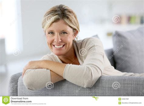 femme mûre de sourire sur le sofa image stock image du lifestyle heureux 64657681