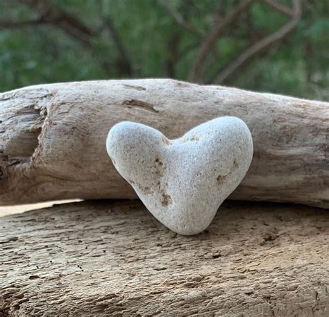 heart shaped rock sitting  top   piece  wood
