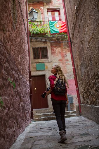 Girl With Blonde Dreadlocks With Camera Explores Old Portugese Town