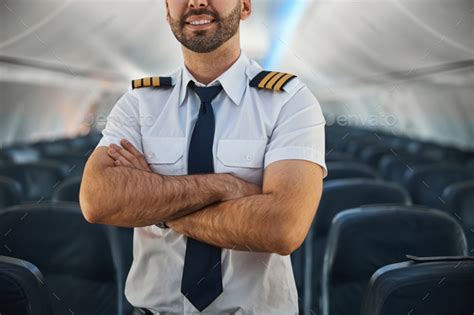 confident male pilot keeping  arms crossed   plane stock photo