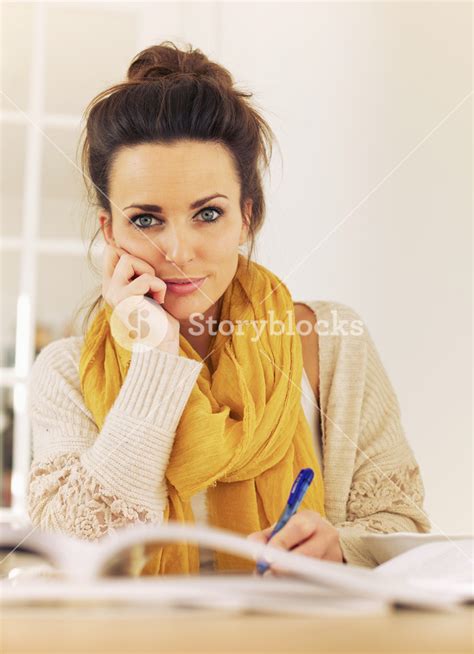 Gorgeous College Girl Writing Something In Her Notes While In Library