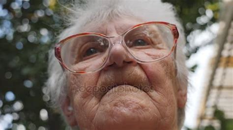 Old Woman Straightens Her Glasses And Looking Forward Portrait Of