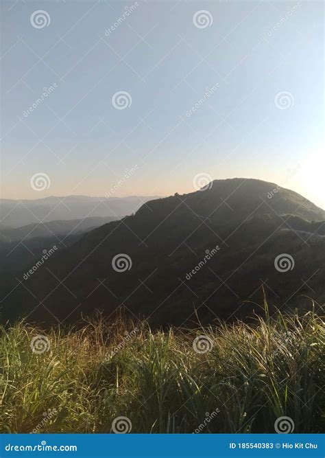 bergen verlicht door zonsondergang stock afbeelding image  gras