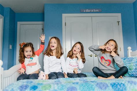 A Group Of Young Girls Making Funny Faces While Sitting On A Bed