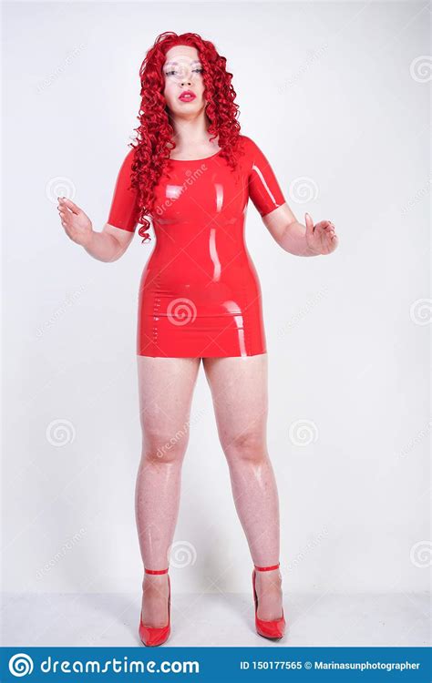 real doll woman wearing red latex rubber dress and posing