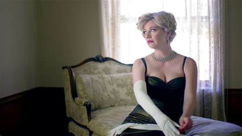 attractive blonde woman wearing a classic vintage fifties dress and white silk opera gloves