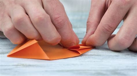 hands folding origami  orange paper stock footage sbv