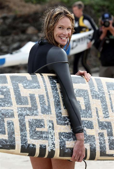 Elle Macpherson Surfing In Black Suit On A Beach In Sydney
