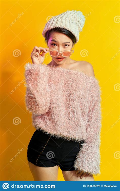 emotional asian girl with colorful makeup posing on yellow background