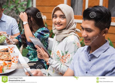 Muslim Asian Woman Using Tab While With Friends Stock