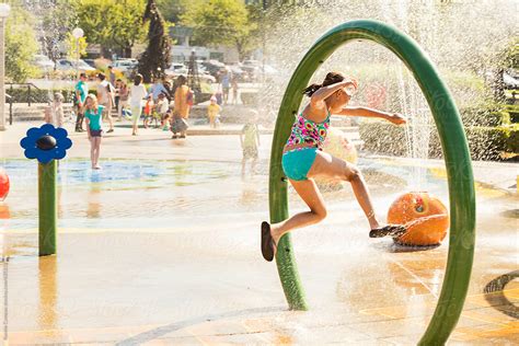 girl playing at water park by stocksy contributor ronnie comeau