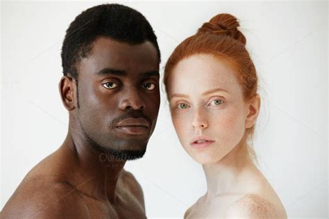 black and white headshot of african man and caucasian woman standing shirtless and looking at