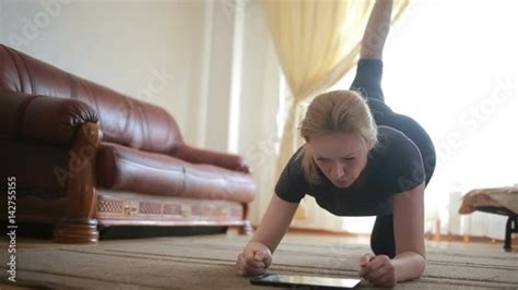 a housewife woman does fitness exercises for the first time looking at