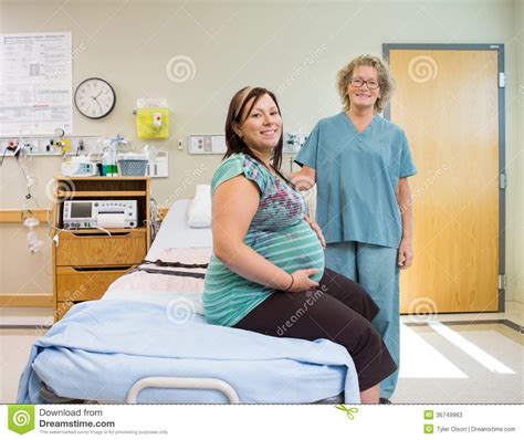 Happy Nurse And Pregnant Woman In Hospital Room Stock