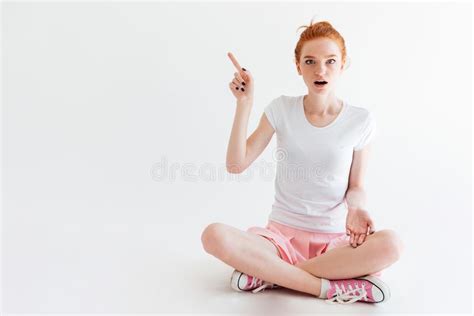 Surprised Ginger Girl Sitting On Floor And Looking At Camera Stock