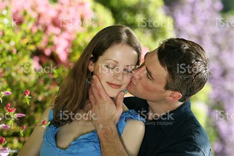 Cheek Kissing Romantic Cute Couple Outdoors In Nature Portrait Stock