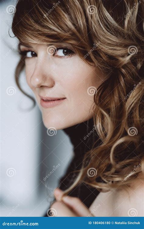Portrait Of A 36 Year Old Woman With Curly Hair And Brown Slanting Eyes