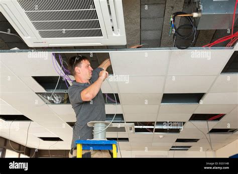 electrician installing cables  suspended ceiling stock photo alamy