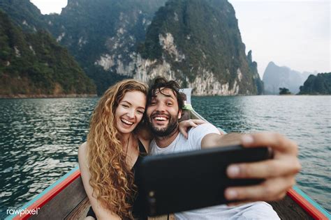 download premium image of couple taking selfie on a longtail boat
