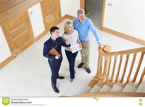 Realtor Showing Mature Couple Around House For Sale Stock