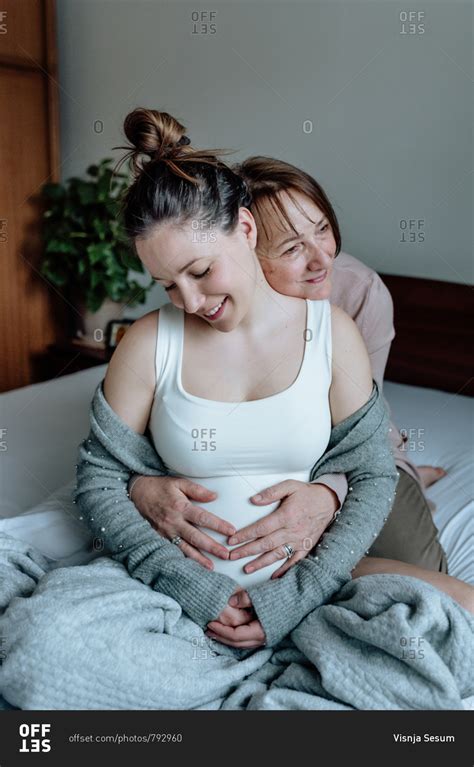 Beautiful Pregnant Woman With Her Mother Hugging Each Other And Holding