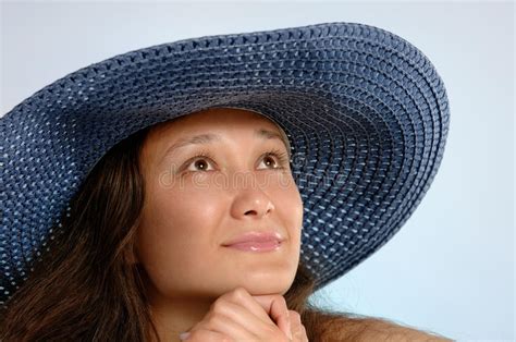woman with sunhat looks over the dunes of a beach stock