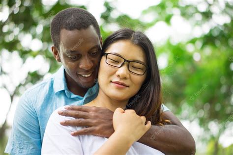 Free Photo Smiling Young African American Man Embracing Happy Asian