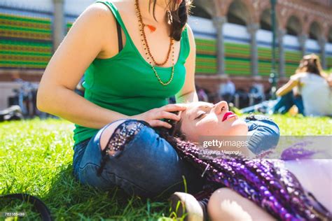 woman giving friend head massage on grass milan italy photo getty images