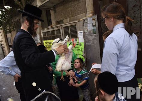 an ultra orthodox jew holds a chicken in kaparot ritual