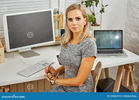 portrait  beautiful blonde woman working  desk   office stock