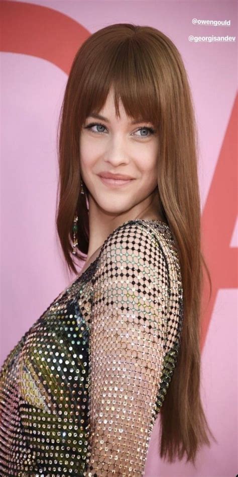 a woman with long red hair and blue eyes wearing a sequin dress at an event
