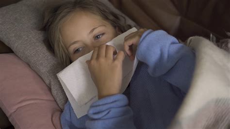 close up of sick caucasian girl sneezing sad stock footage sbv