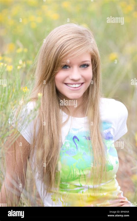 Portrait Of Teenage Girl 17 18 Years Old Sitting In Field Of Flowers