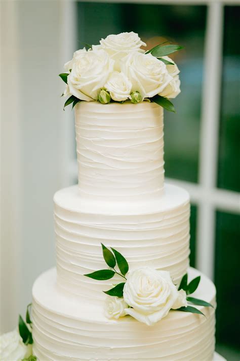 this stunning and modern all white wedding cake was made even more