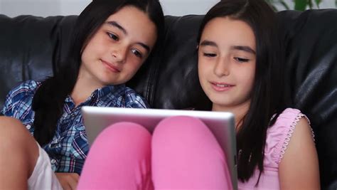 two happy teenage girls having fun using tablet computer hd stock footage clip