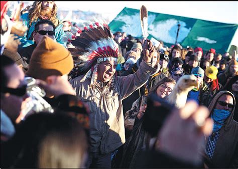 a crowd gathers in celebration at the oceti sakowin camp after it was announced that the us army