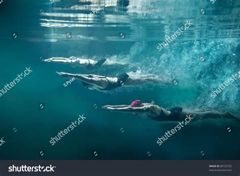 professional three swimmers under water isolated stock