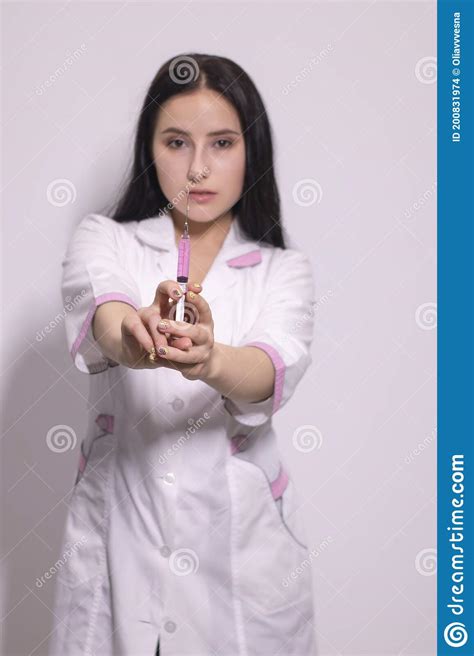 Brunette Nurse In White And Pink Medical Gown With Syringe On Greyish