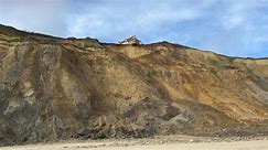 Homes dangling on a cliff edge after coastal erosion
