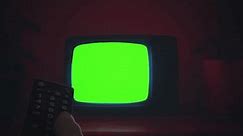 Changing Channels TV Green Screen Remote Control Vintage Television Zoom In. Remote control changing channels on an old vintage green screen television, zoom in.