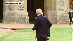 King Charles III leads President Biden away from a guard