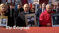 Putin leads Immortal Regiment parade with a photo of his father