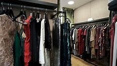 Shooting Three rows of hangers along walls clothes in store, long line with black hanger with dresses. skirts, coats, sweaters, jackets, pants, blouses of different materials. Wool silk leather satin