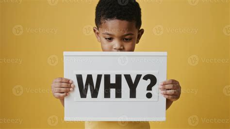 A young African boy holds a sign with the word WHY in bold letters. The ...
