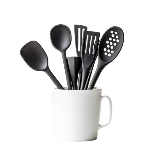 A collection of black kitchen utensils in a cup on a bright transparent ...