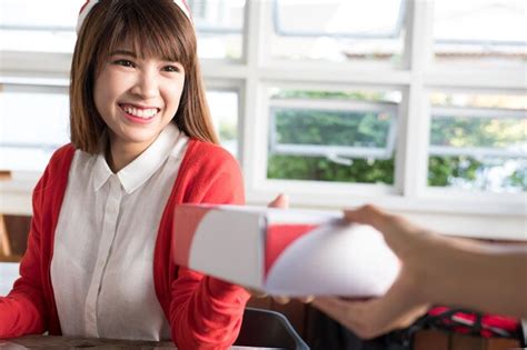 Smiling young woman giving package to customer | Premium Photo