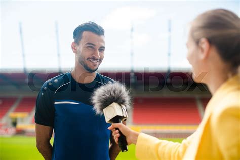Reporter interviewing football player in a stadium | Stock image ...