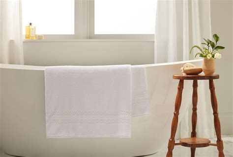 The Ritz-Carlton bath mat hung over standing bathtub